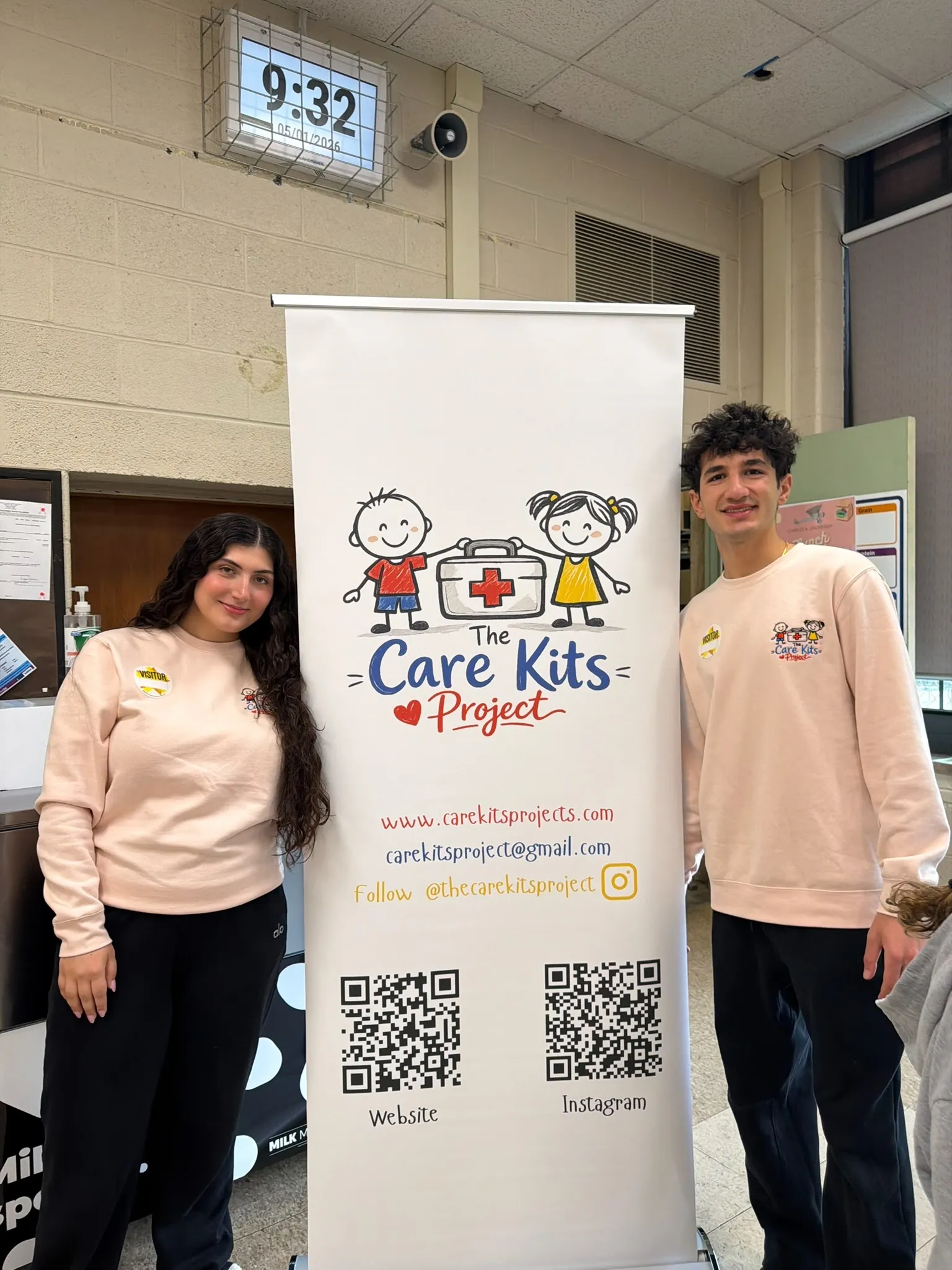 Lilyana and Alexander with the Care Kits Project banner at a school workshop